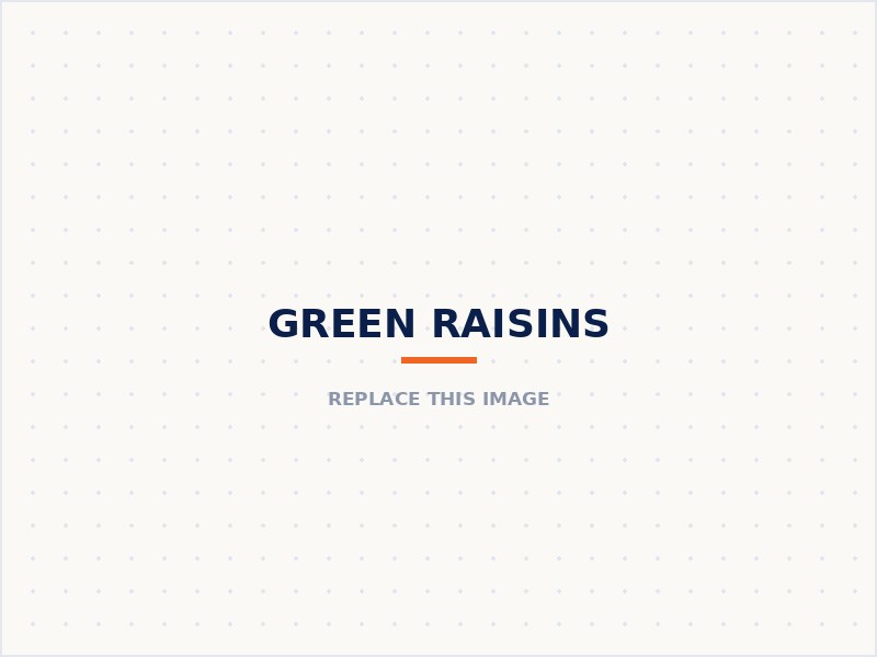 Green raisins in a bowl with fresh green grapes and a vine leaf